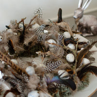 kranz aus wachteleiern, federn und moos