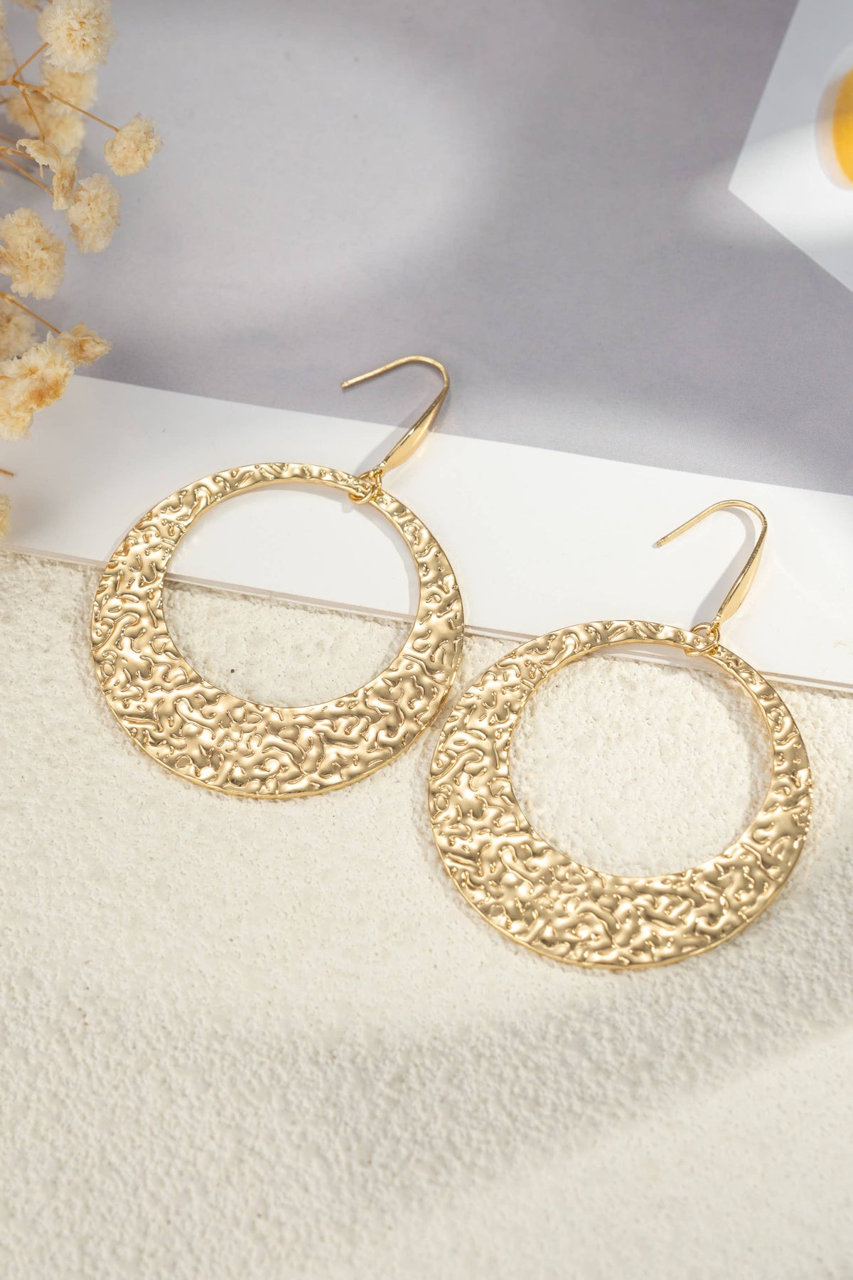 Goldene Ohrringe mit texturierten, durchbrochenen Ringen